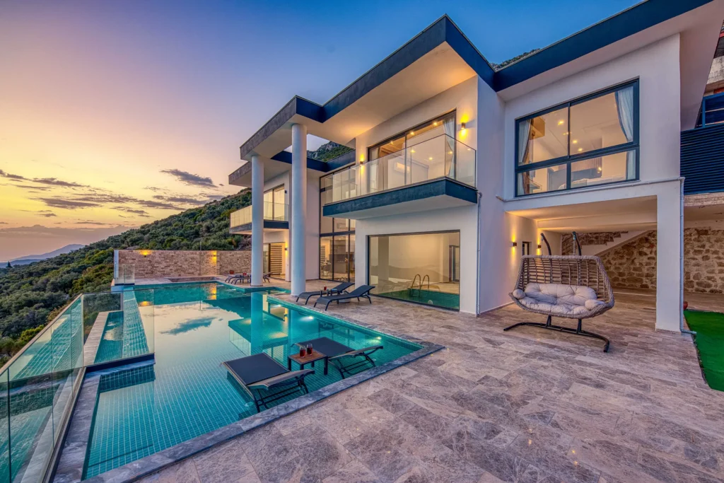 Modern luxury villa with infinity pool at sunset